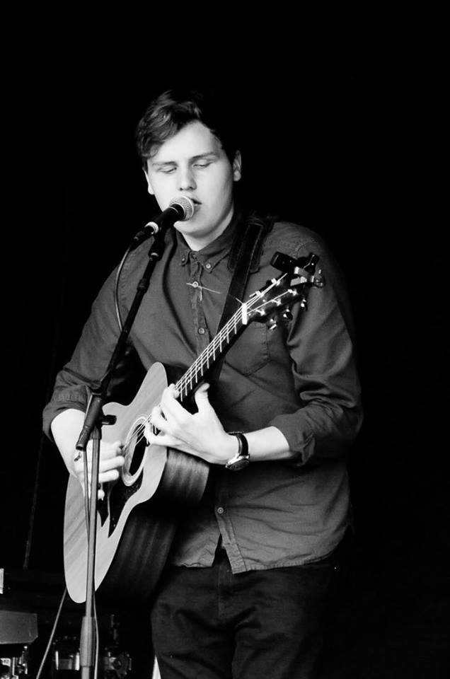 an image of a young man playing guitar and singing