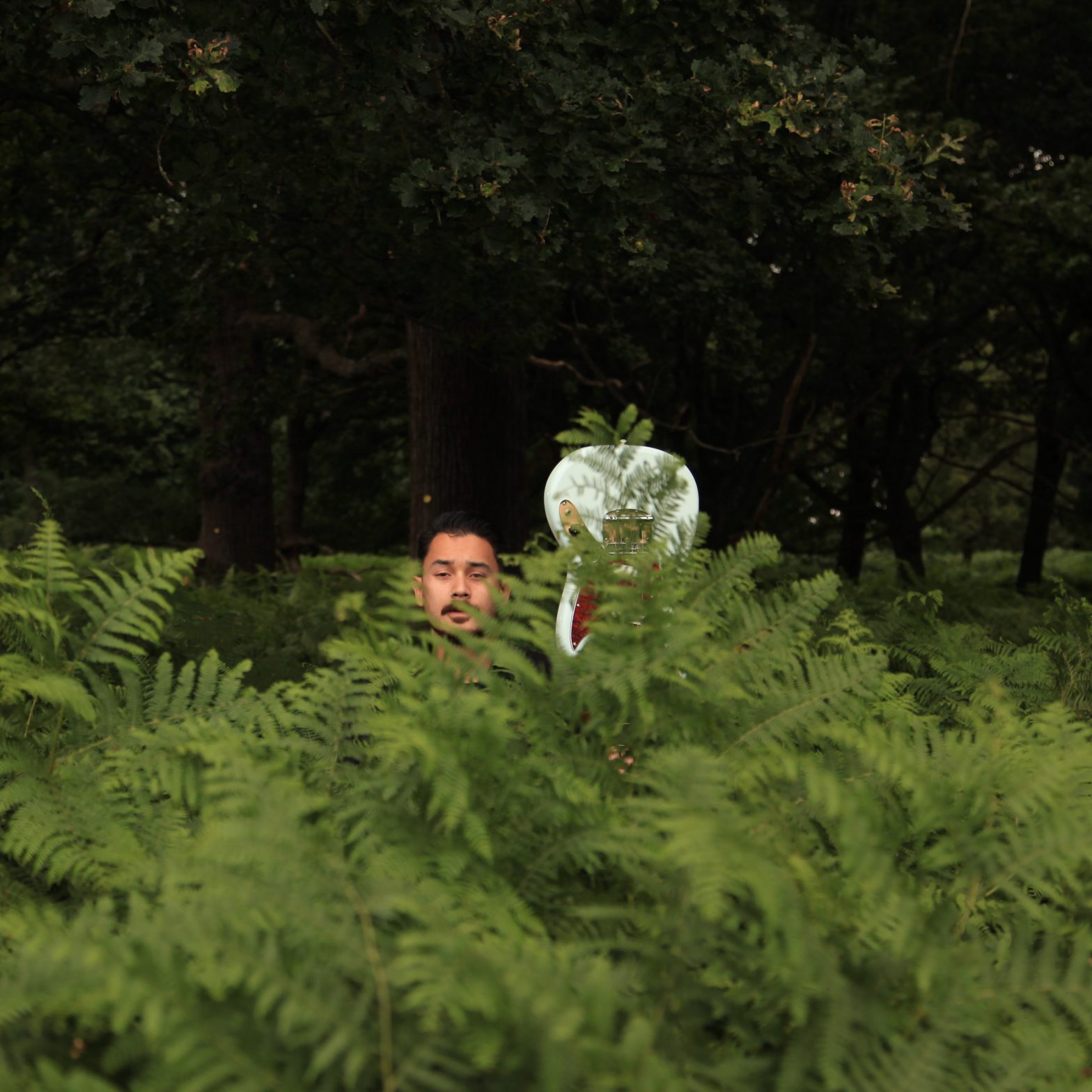photo of Oliver Han behind a bush