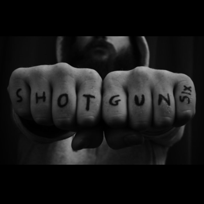 photo of man holding up shotgun six knuckle print
